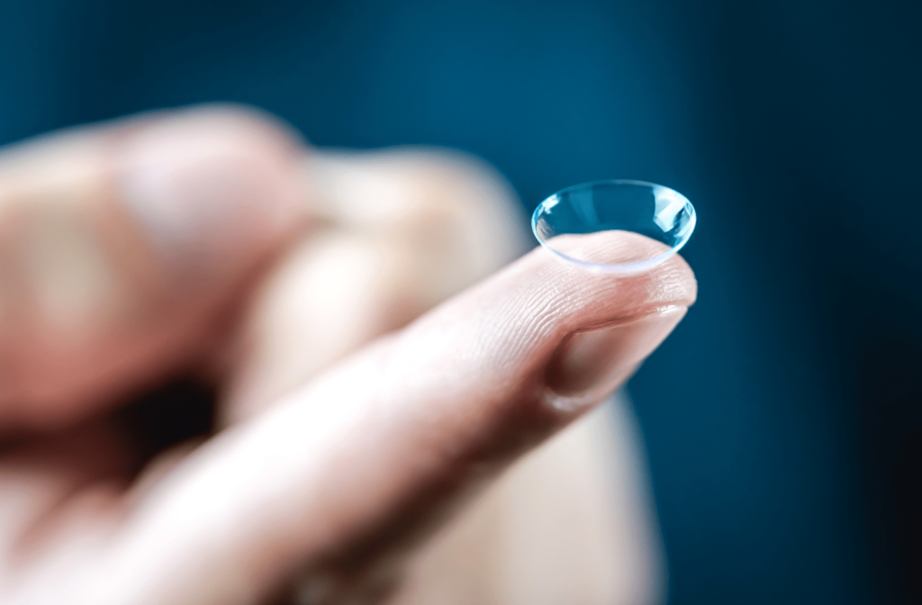 A man holding a contact lens on his index finger