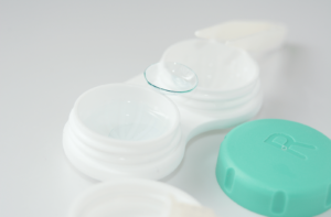 A pair of contact lenses sitting on a contact lens case.