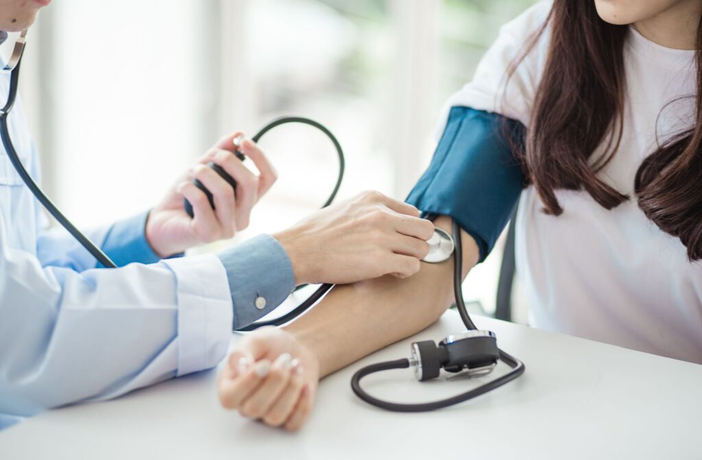 A doctor uses a blood pressure monitor to determine a female patient's blood pressure